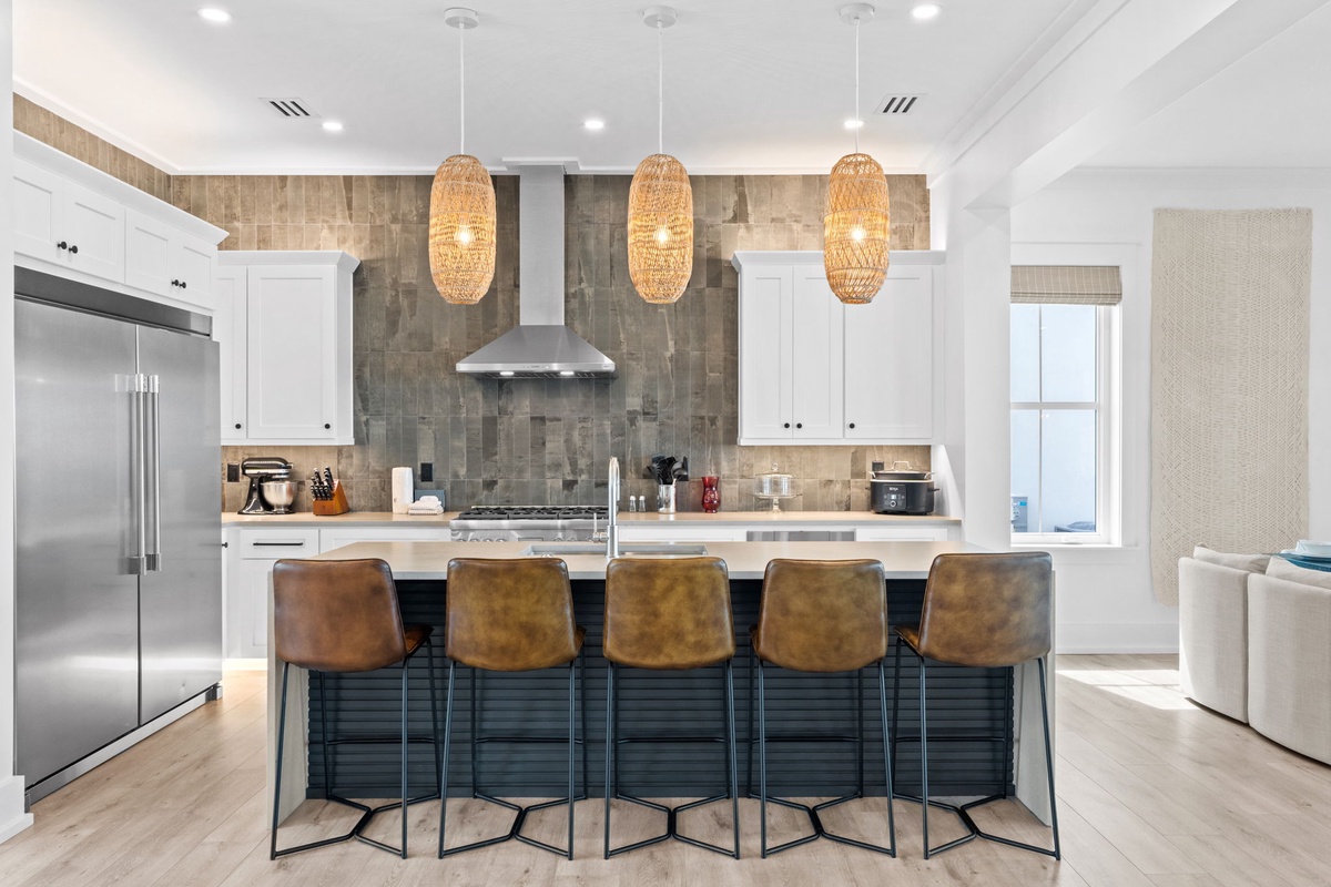 Gather around the spacious island with seating for five, under warm woven pendant lights, where your morning coffee and evening meals become memorable moments in this beautifully appointed kitchen.