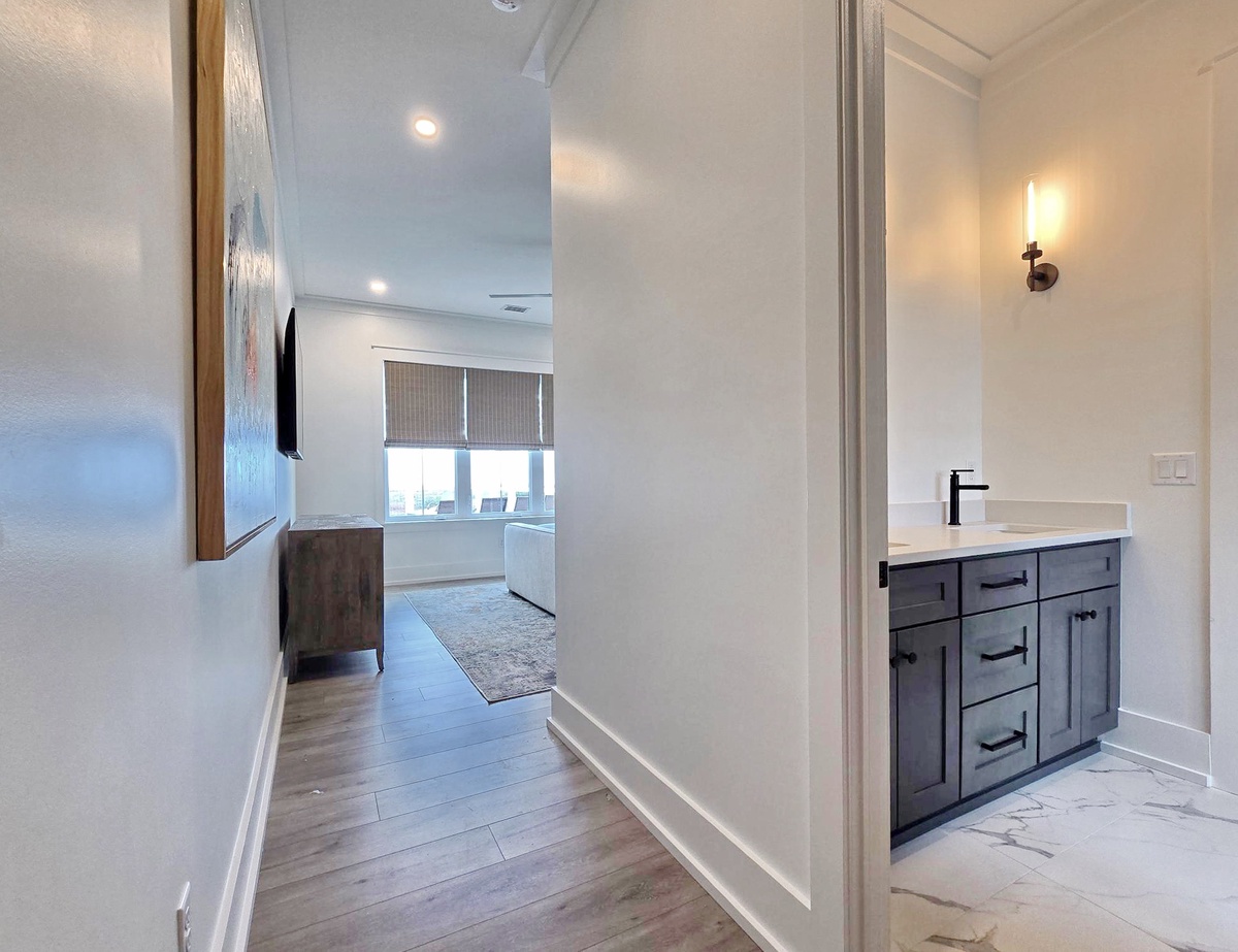 Discover your sleek bathroom sanctuary with modern vanity and marble flooring, perfectly positioned near your spacious living area.