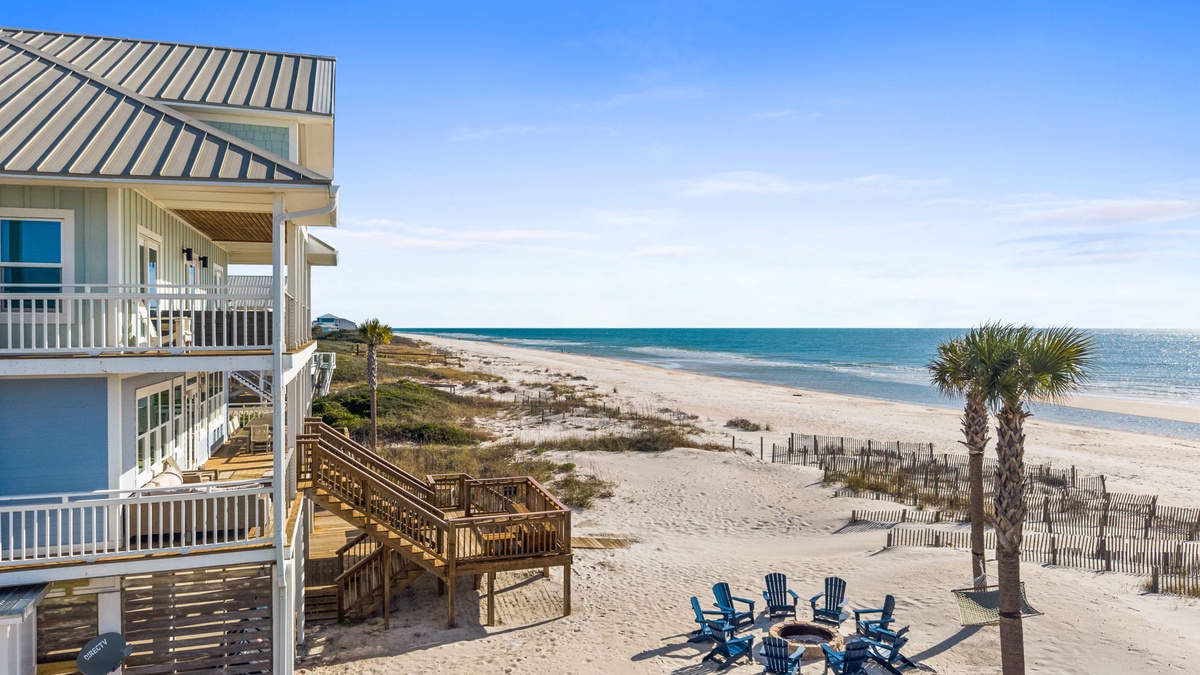 Coastal property offers direct beach access with wooden walkway leading to pristine sandy shores and crystal-clear waters.