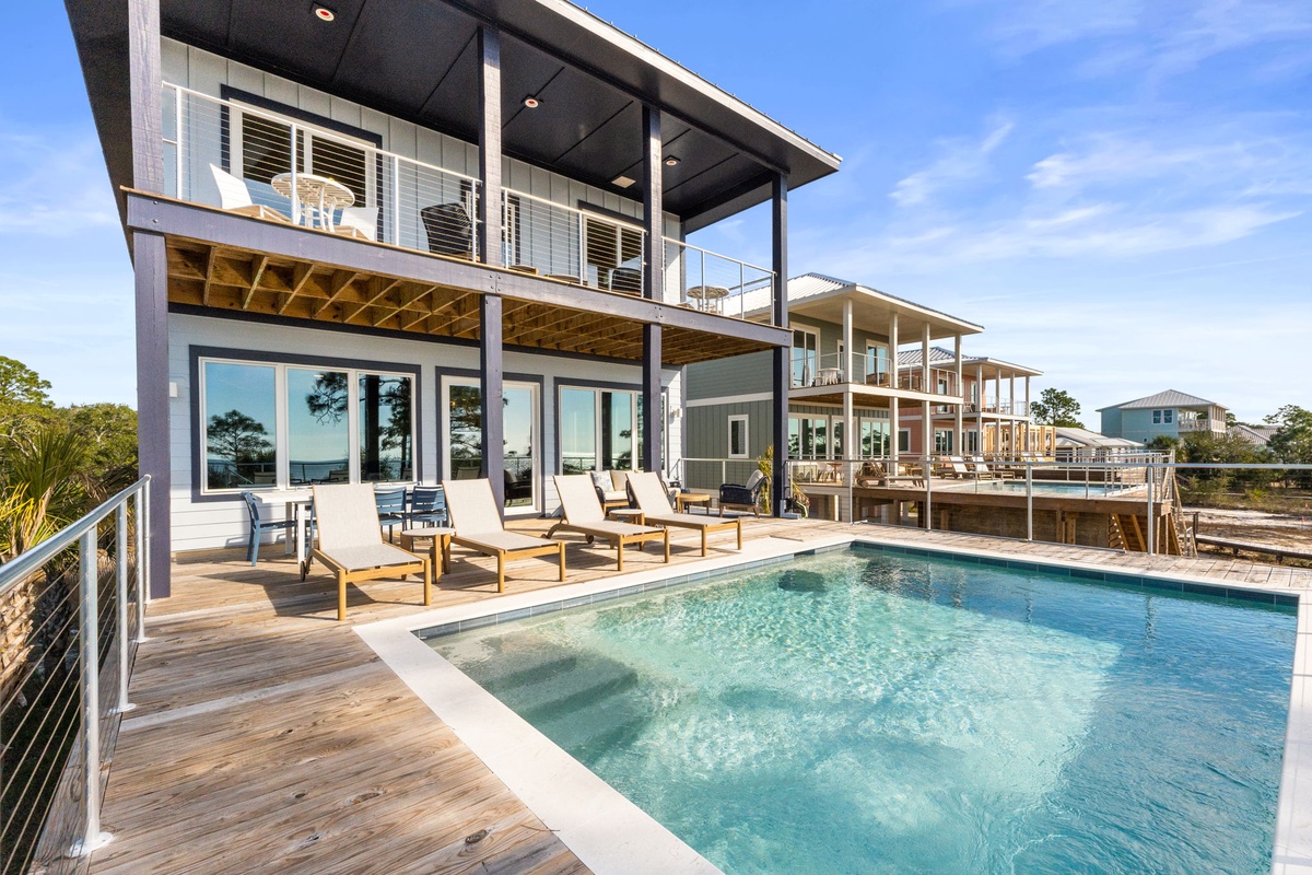 Modern beachside retreat with private pool, spacious decks, and contemporary design nestled among coastal homes.