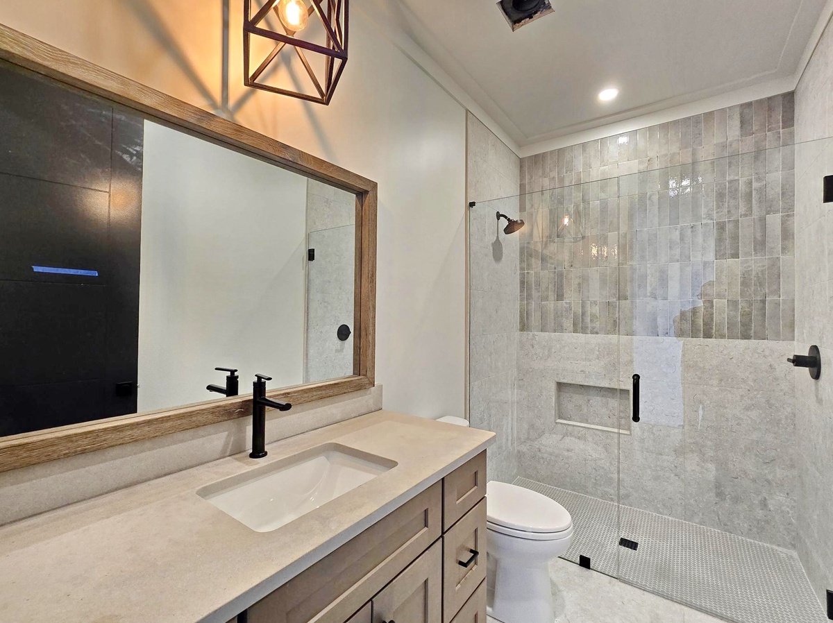 Unwind in your sophisticated bathroom featuring a spa-like walk-in shower with beautiful stone tiles and modern finishes throughout.
