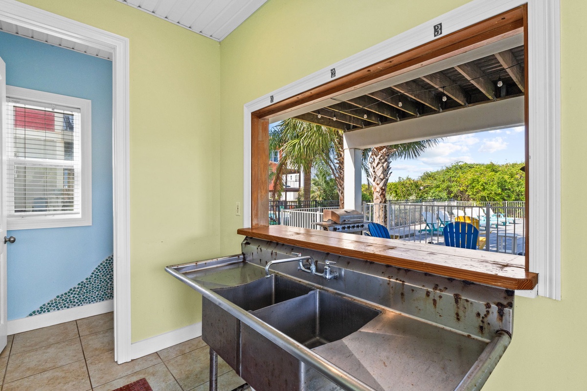 Step into your private outdoor kitchen and gaze out at swaying palms, sunny pool deck, and lush tropical surroundings—perfect for easy entertaining or unwinding after a day of adventure.