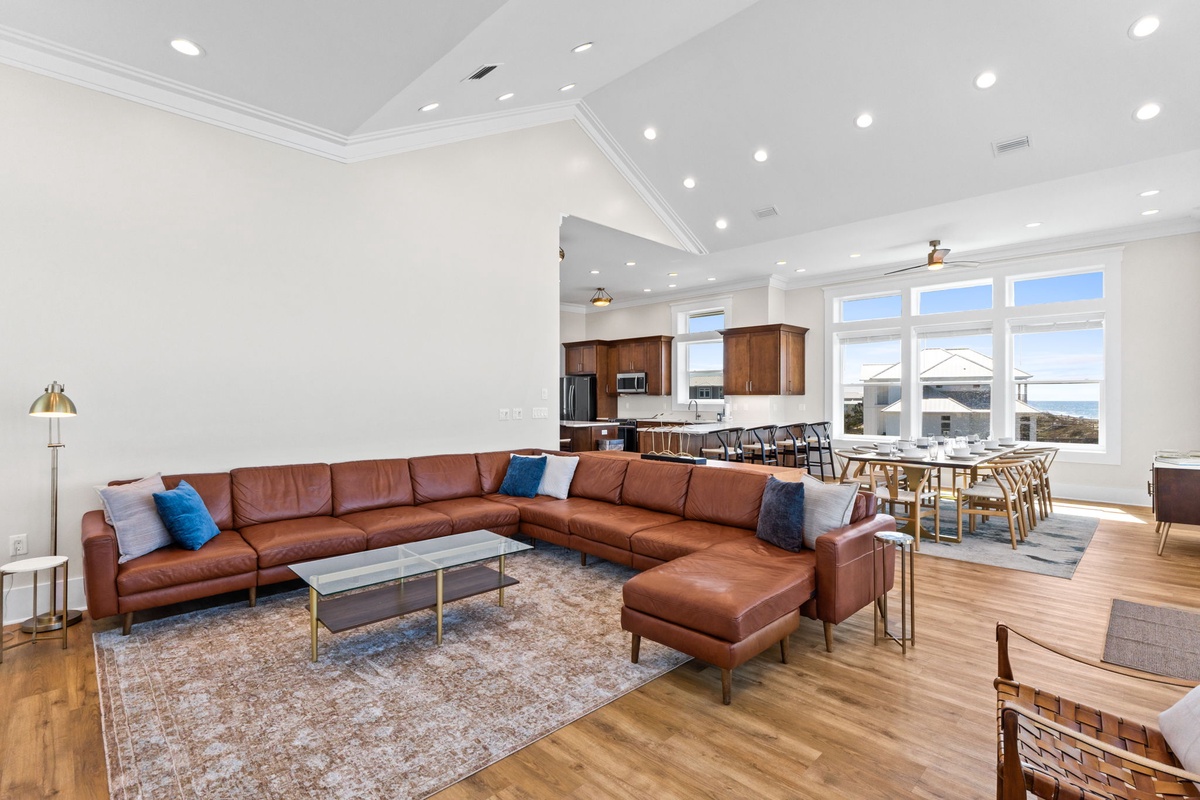 Relax in your open-concept living space featuring a luxurious leather sectional and panoramic windows that flood the room with natural light.