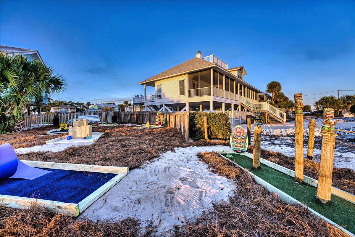 Beachfront property featuring tiki-themed miniature golf course and outdoor recreational areas with tropical landscaping.