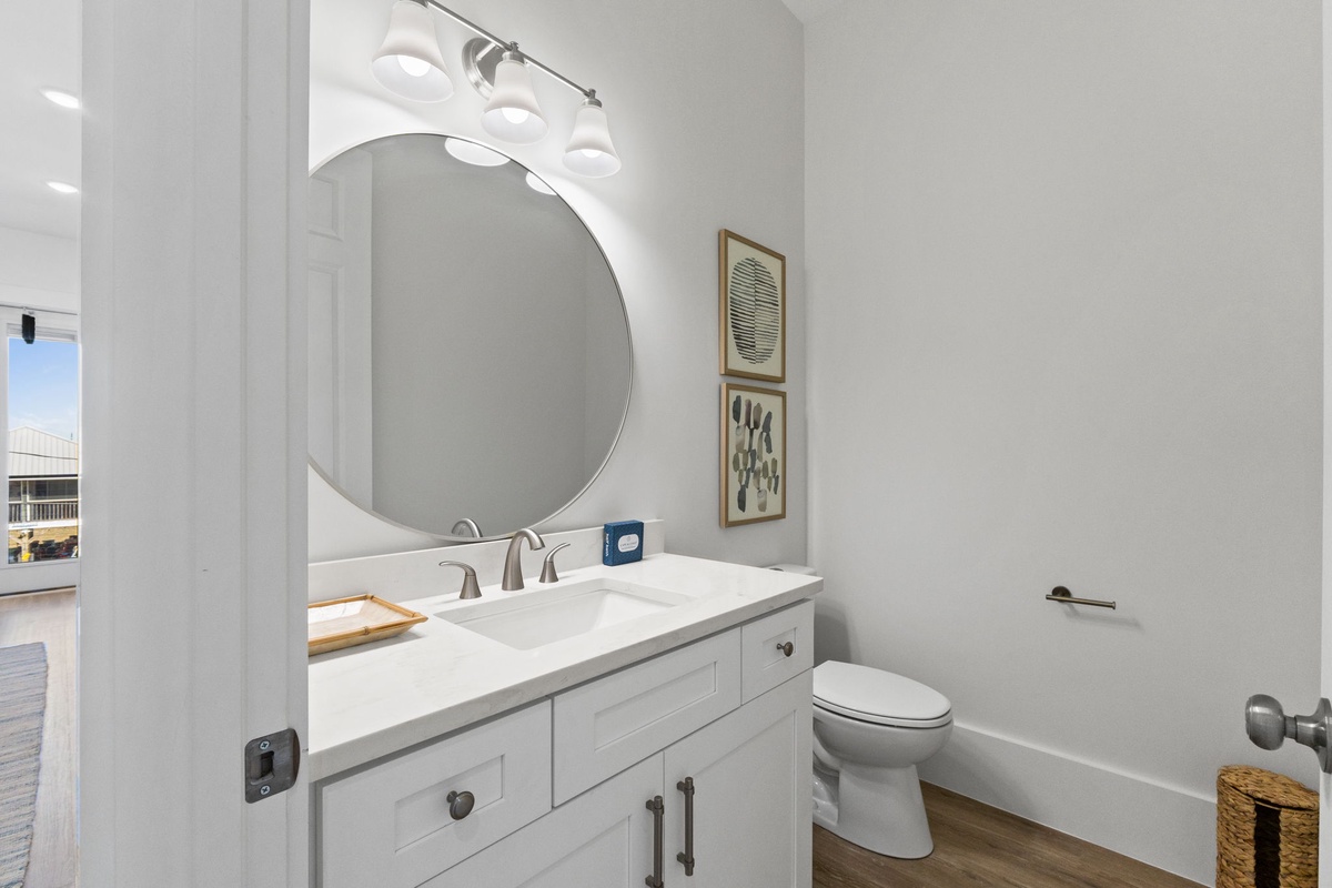 Step into your pristine bathroom featuring a spacious vanity with ample storage and stylish round mirror for your morning routine.