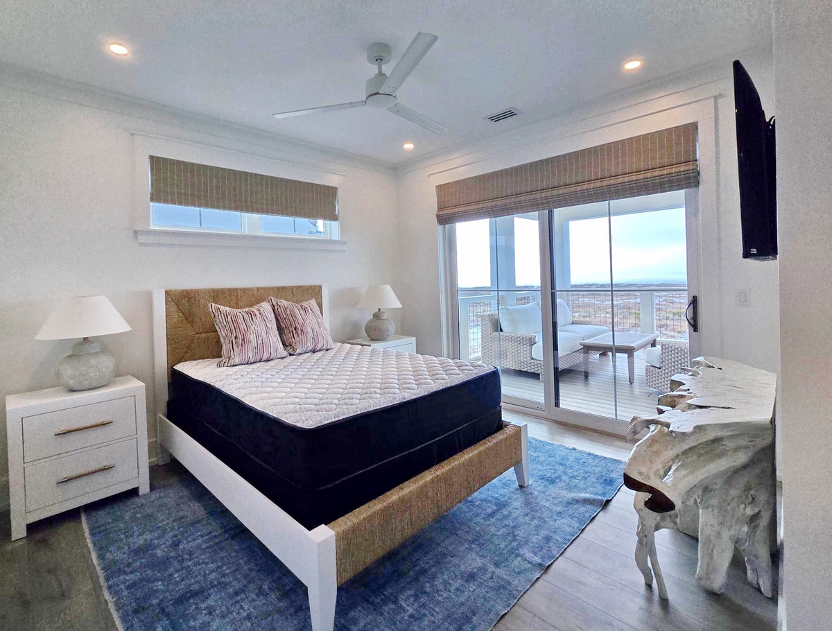 Unwind in your bright bedroom with private balcony access, cooling ceiling fan, and flat-screen TV for perfect relaxation.