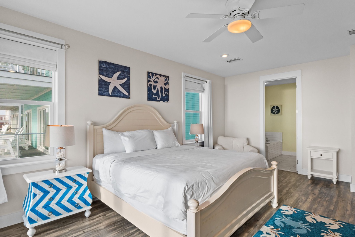 Drift off to sleep in your coastal-inspired bedroom with crisp linens, ocean artwork, and gentle ceiling fan breeze.