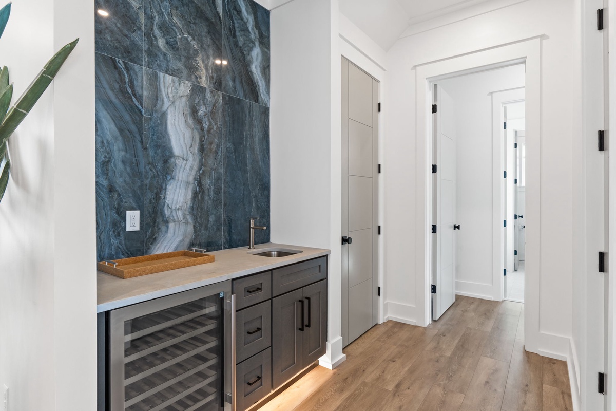 Your private wet bar awaits with stunning marble accent wall and wine cooler for perfectly chilled evenings.