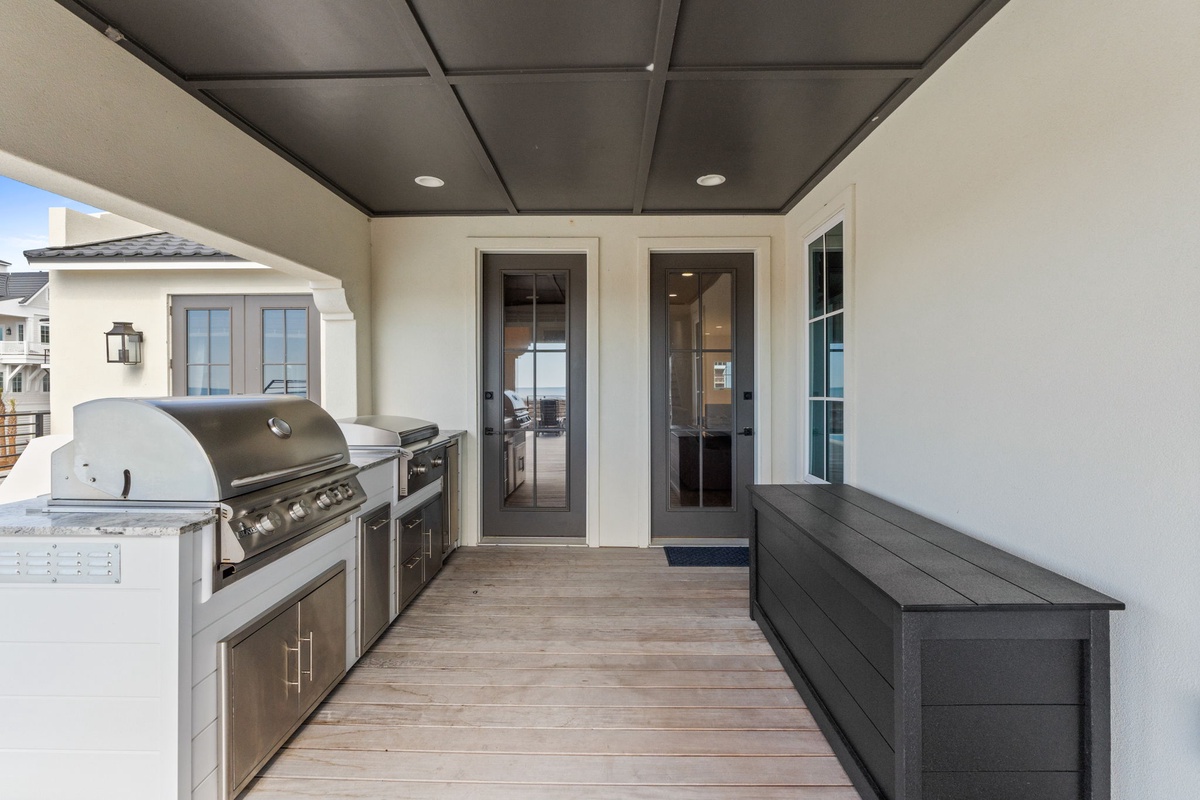 Your outdoor kitchen awaits with premium grill and sleek storage—perfect for memorable meals under the covered terrace.