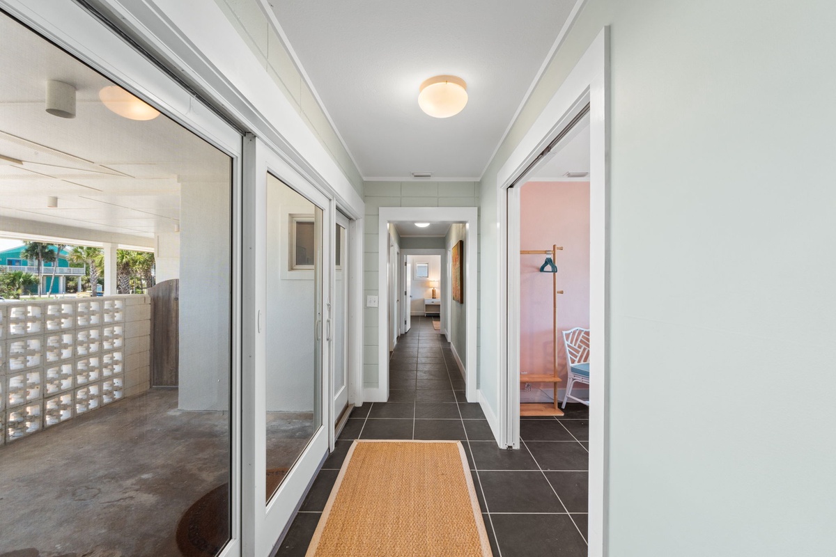 Step into your bright, welcoming hallway with sleek tile floors leading you to private bedrooms and an inviting outdoor patio—your perfect retreat awaits.