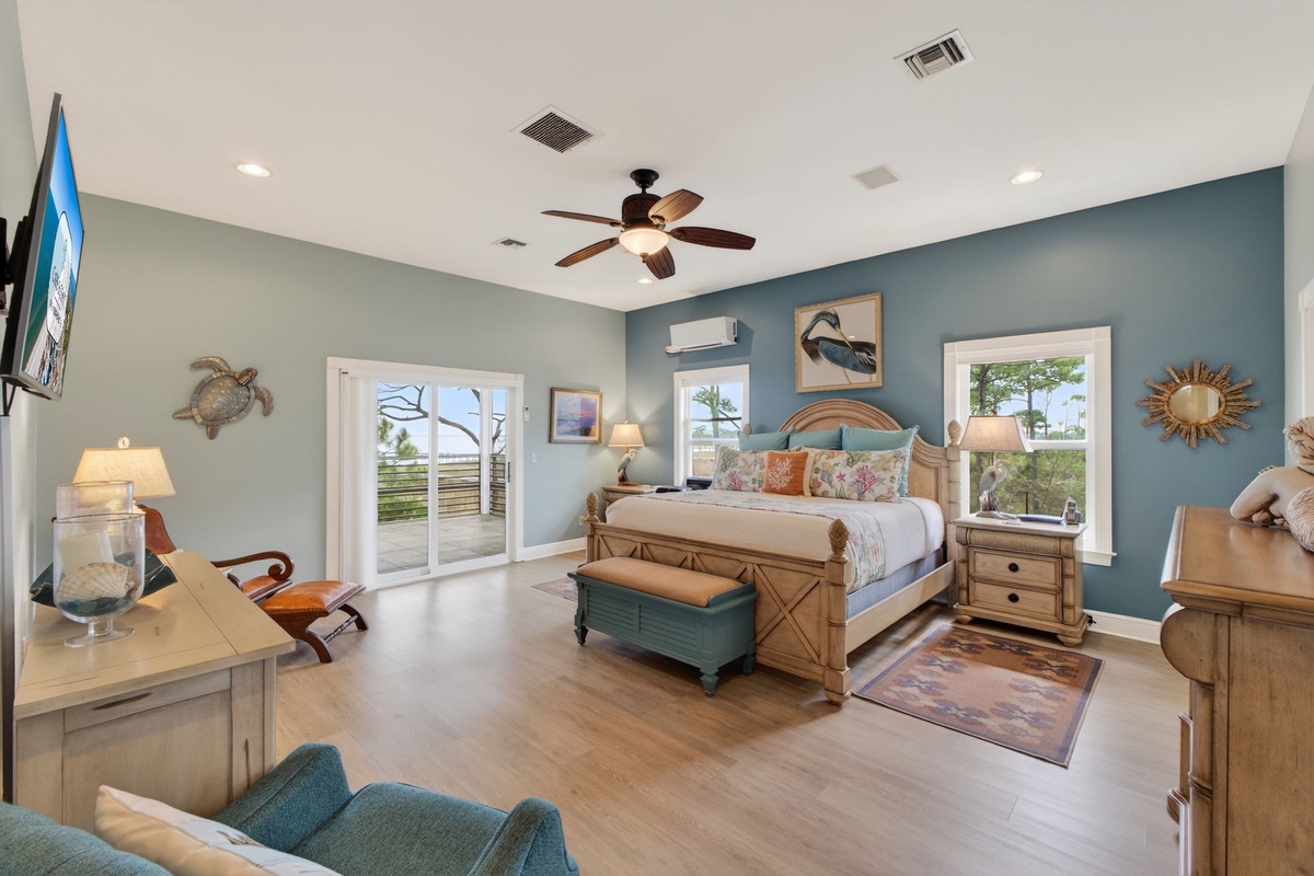 Your coastal-themed master bedroom features ocean-inspired decor, comfortable seating, and French doors opening to your private outdoor space.