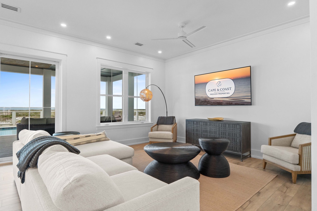 Sink into plush seating in your bright living room, where coastal elegance meets comfort. Large windows frame stunning views, and stylish touches invite you to relax and unwind.