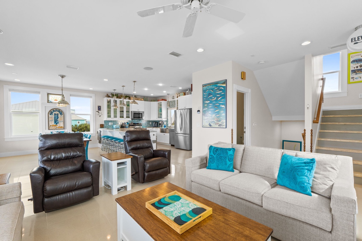 Relax in your bright, open living space with turquoise accents, modern kitchen, and comfortable seating perfect for unwinding.