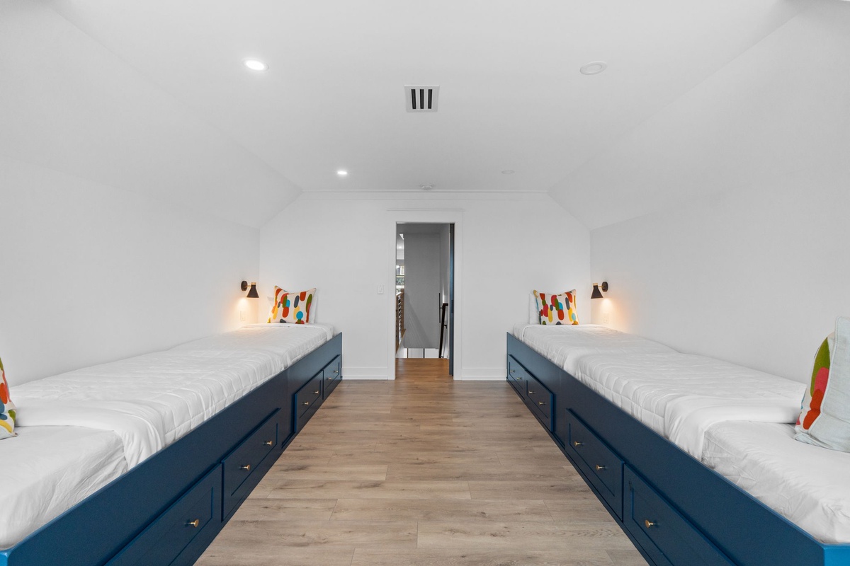 This spacious bedroom offers flexible sleeping for your group, with two large beds featuring built-in storage, warm reading lights, and a private en-suite just steps away.