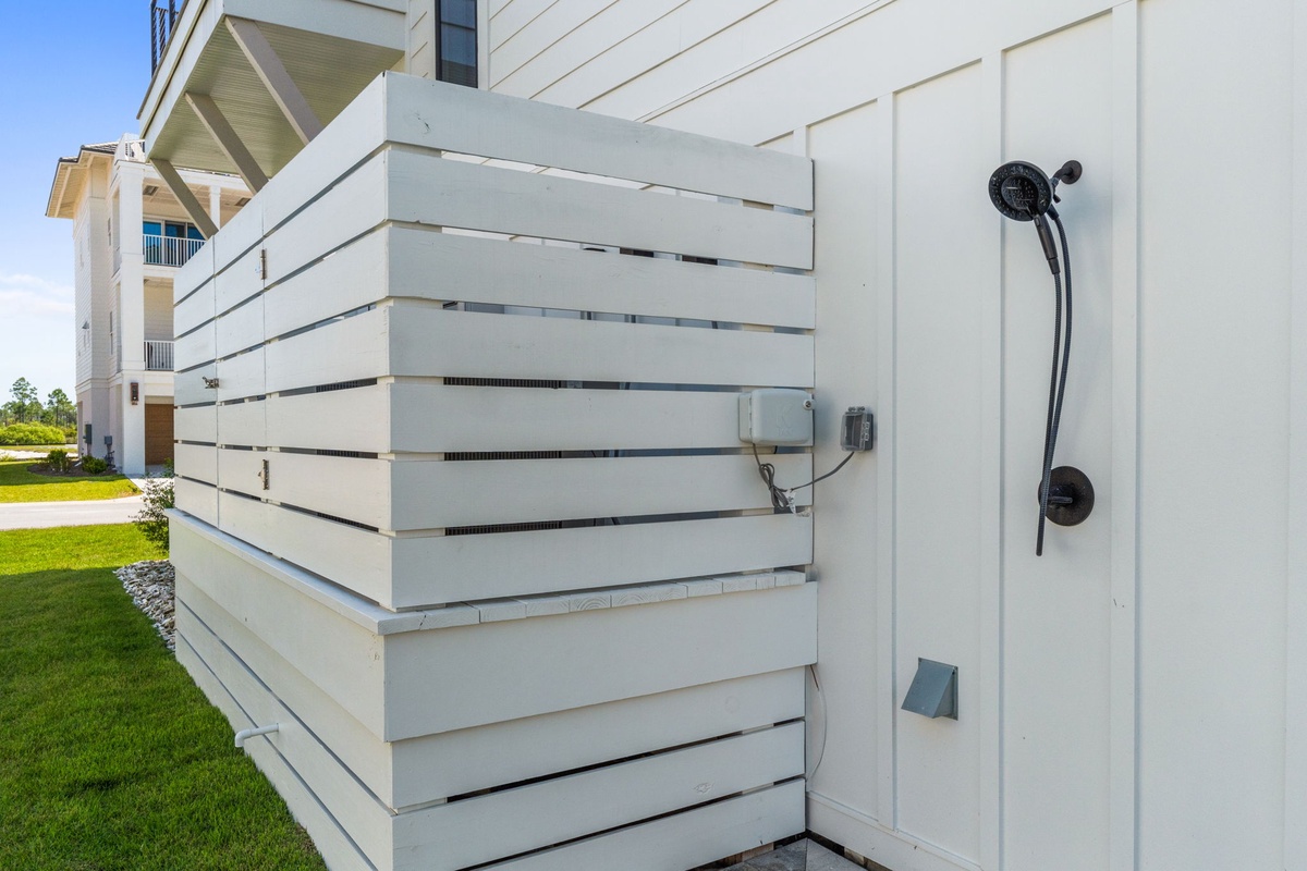 Outdoor shower with privacy slats, perfect for rinsing off after beach visits or pool time—convenient access built right into the property.