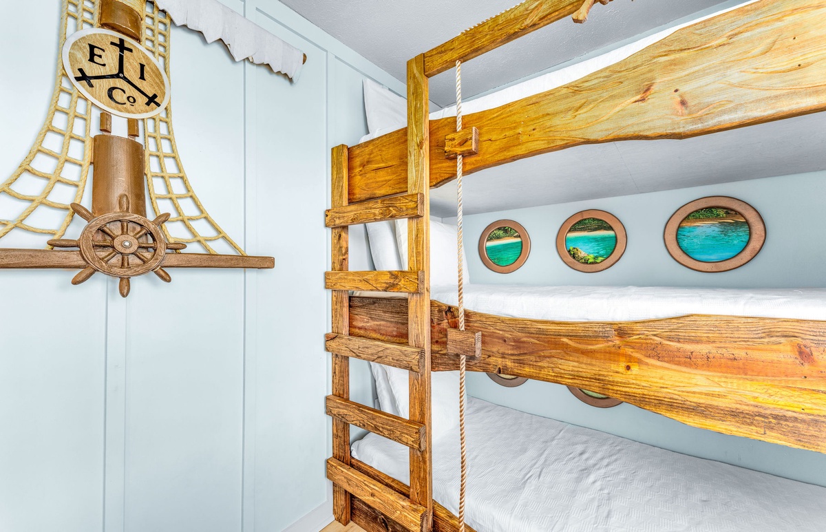 Your kids will love this ship-themed bunk bed with climbing ladder and nautical portholes—adventure awaits in their own pirate cabin!