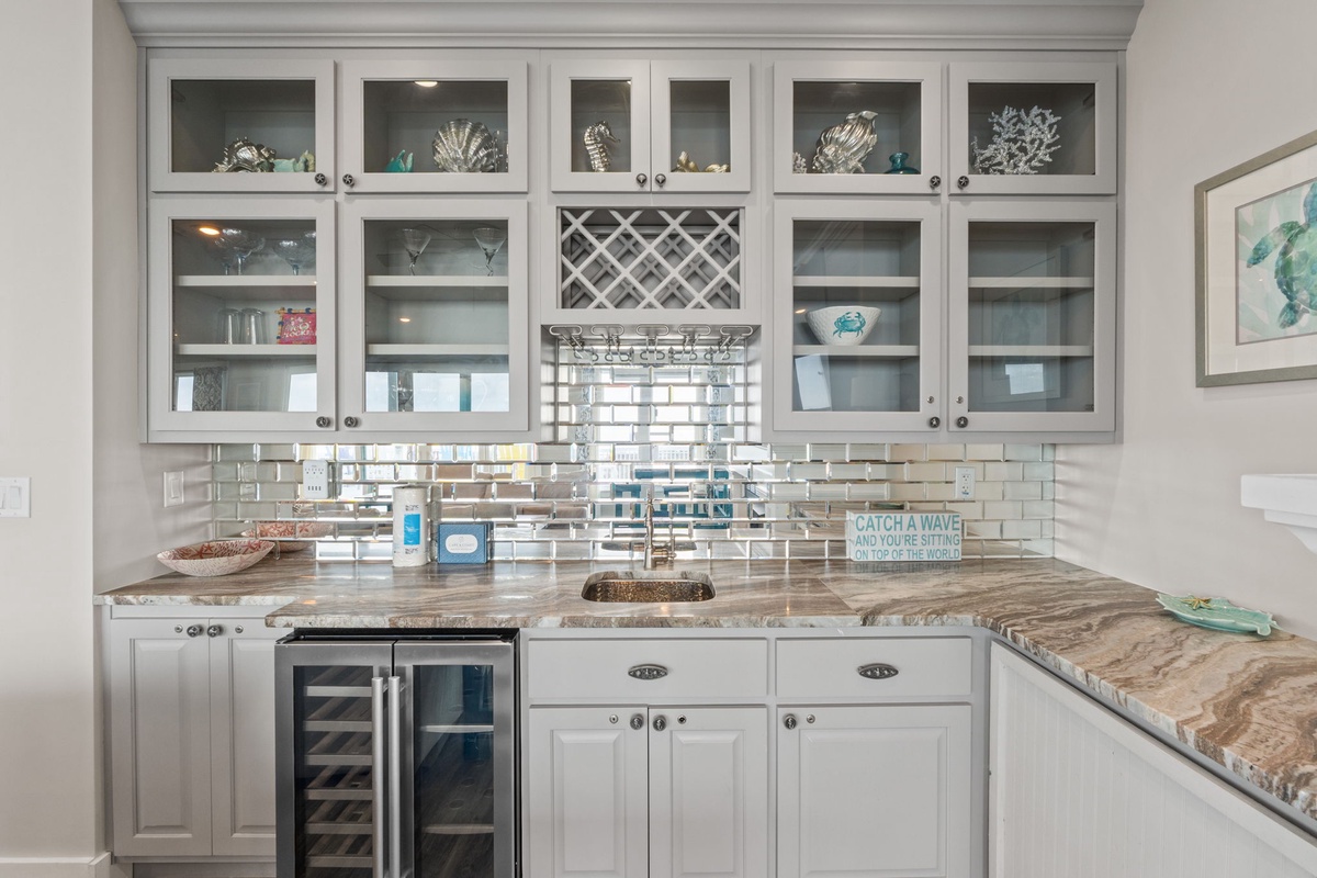 Your kitchen blends coastal charm with modern convenience, featuring granite counters, glass cabinets, and gleaming tile backsplash for memorable meal prep.