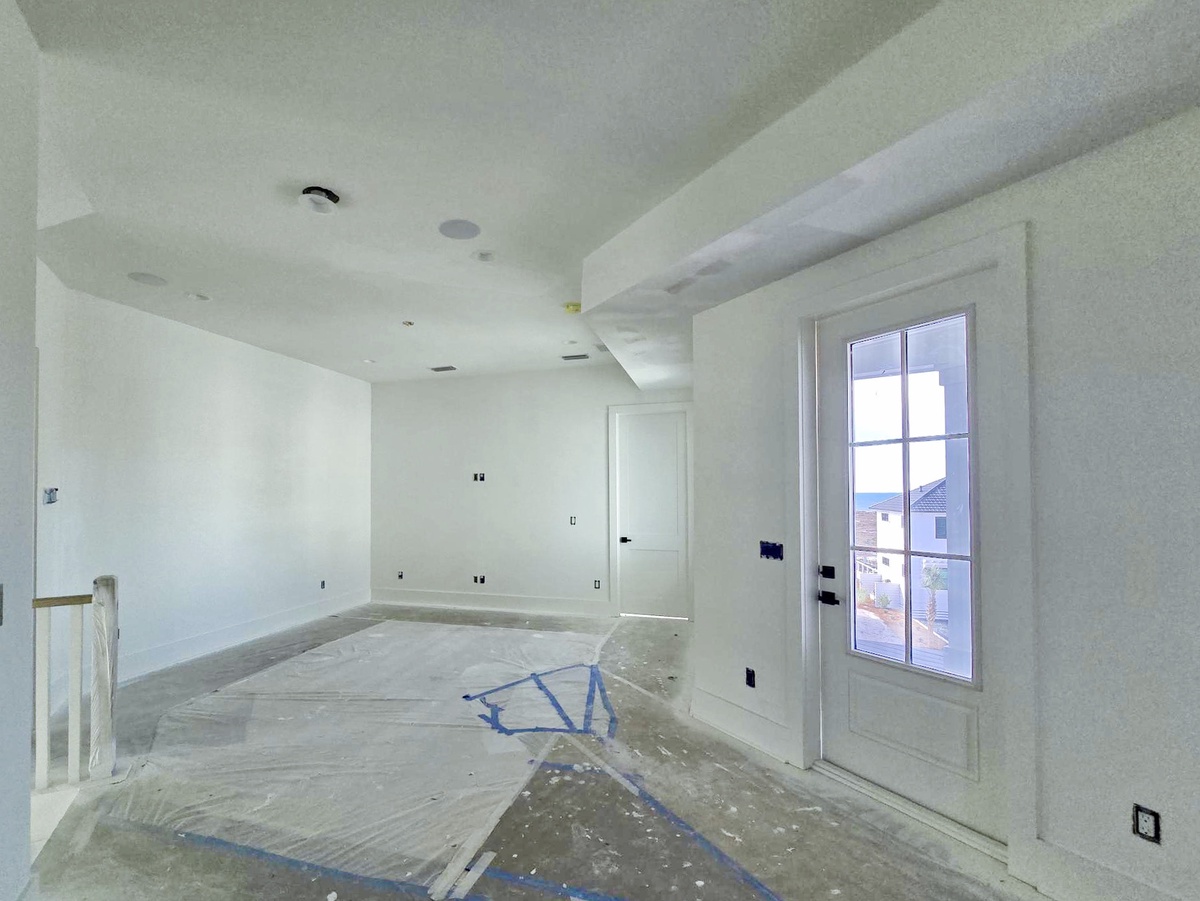 Your future retreat is taking shape with fresh white walls, exposed beams, and windows framing neighborhood views.