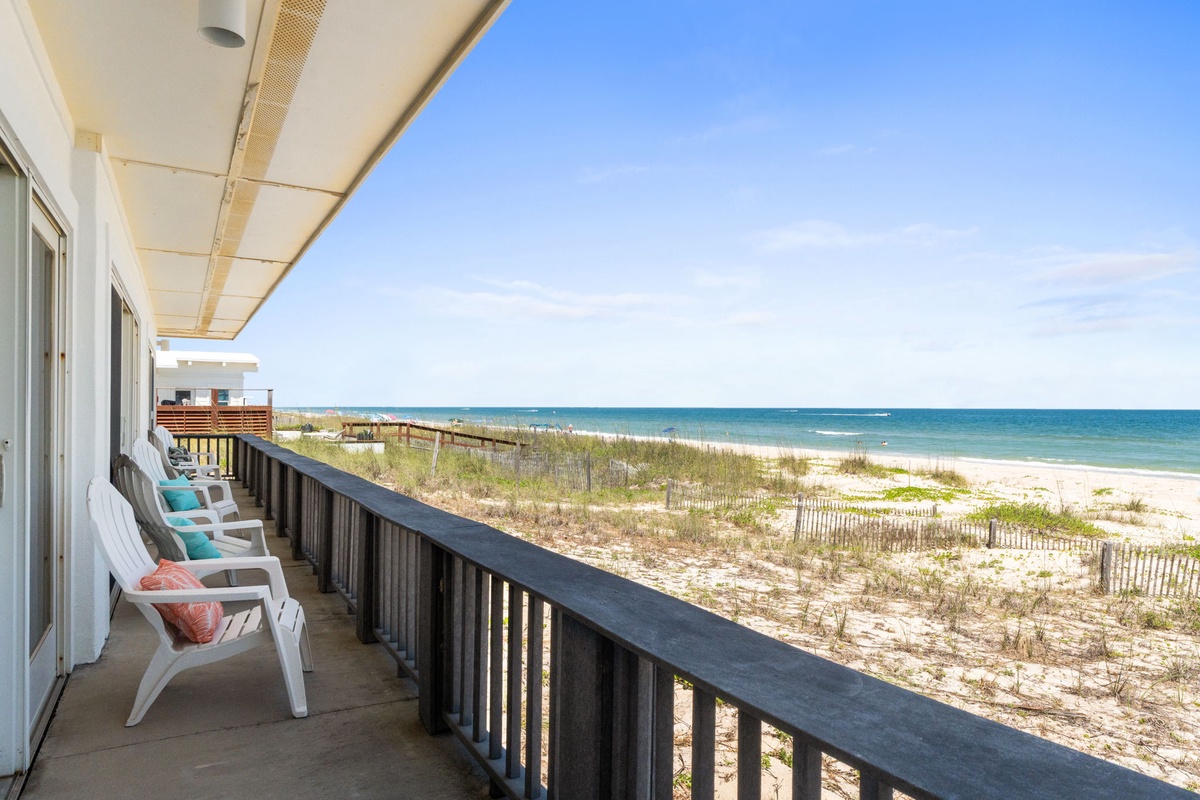 An expansive balcony offers stunning beachfront vistas across turquoise waters and pristine white sand. Settle into the deck chairs and soak up the coastal tranquility just steps from your door.