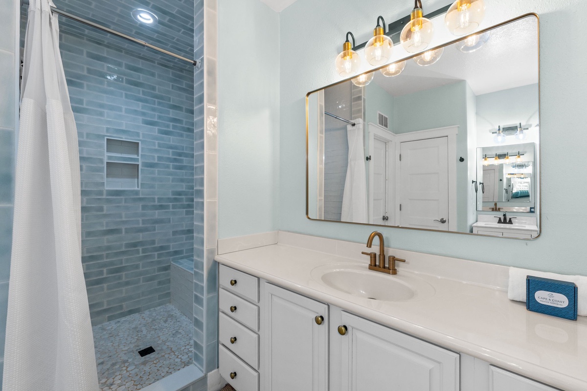 Your bright, spa-inspired bathroom features elegant blue subway tile, a spacious walk-in shower, and modern brass fixtures that blend style with comfort for a truly relaxing retreat.
