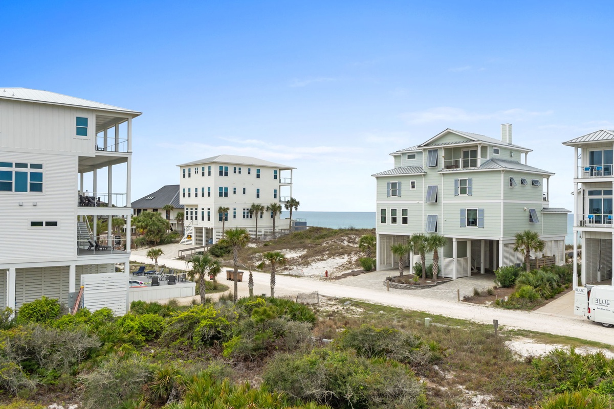 Coastal vacation homes nestled among natural dunes and palm trees, just steps from pristine beach access.