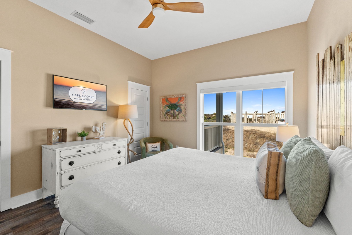 Your peaceful bedroom retreat features a comfortable bed and stunning coastal views through large windows, perfect for morning coffee.