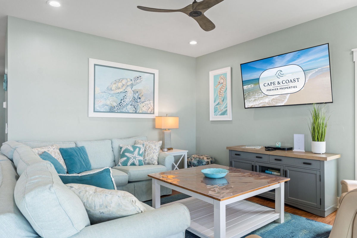 Sink into plush seating with ocean-themed accents, enjoy your favorite shows on the flat-screen TV, and feel the coastal breeze from the ceiling fan as you unwind in this light-filled retreat.