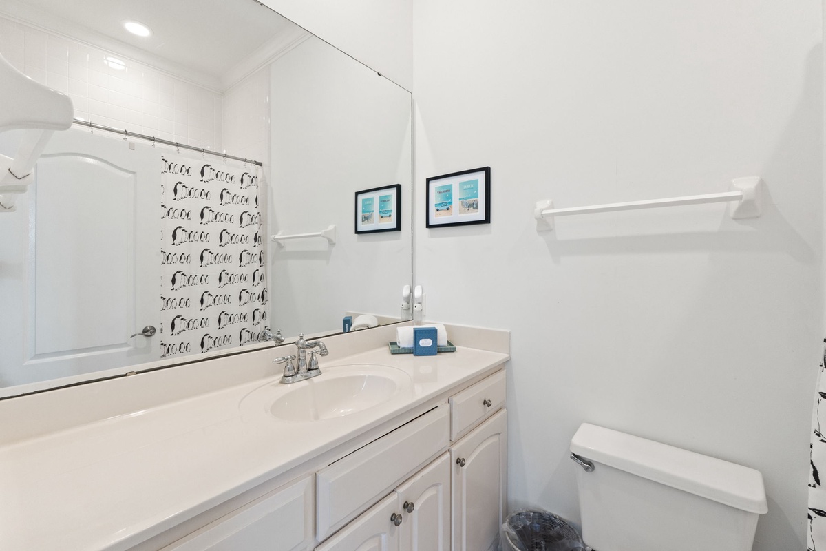 Step into your pristine bathroom featuring clean white surfaces, ample counter space, and thoughtful coastal touches that create a refreshing retreat.