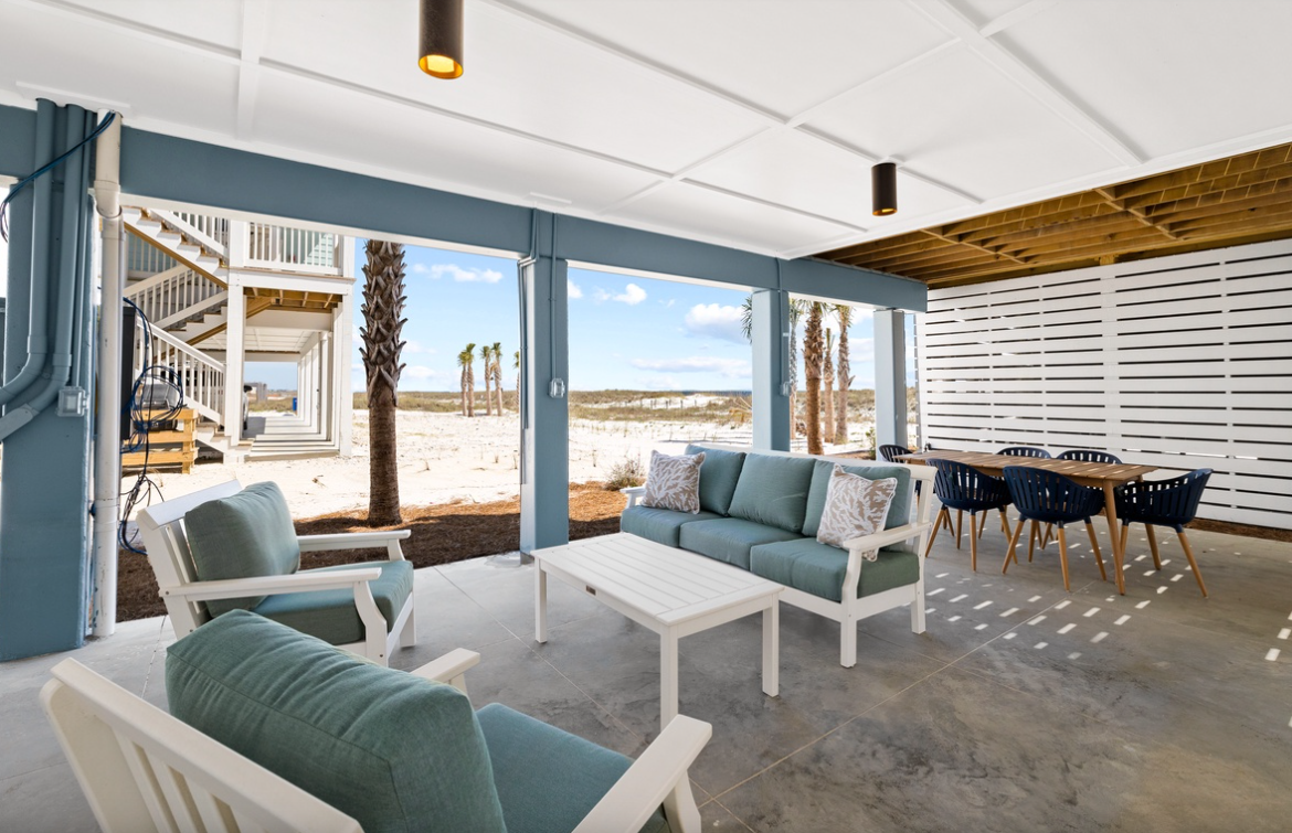 Unwind in your coastal retreat where soft teal seating and ocean breezes create the perfect beachside sanctuary for relaxation.