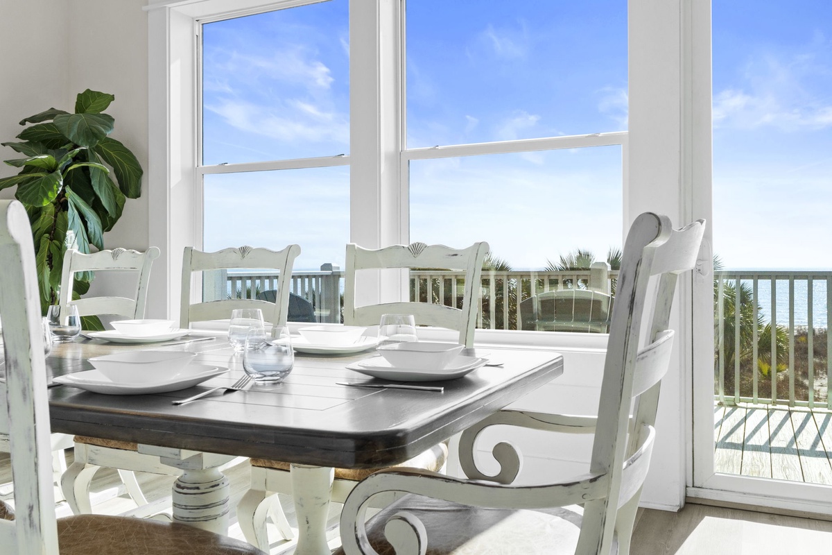 Your elegant dining space opens to breathtaking ocean views through floor-to-ceiling windows, perfect for memorable meals with natural light.