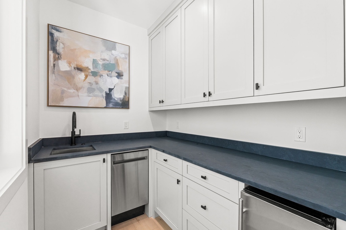 Prepare meals in your elegant kitchen with sleek countertops, modern appliances, and stylish artwork creating an inspiring culinary space.
