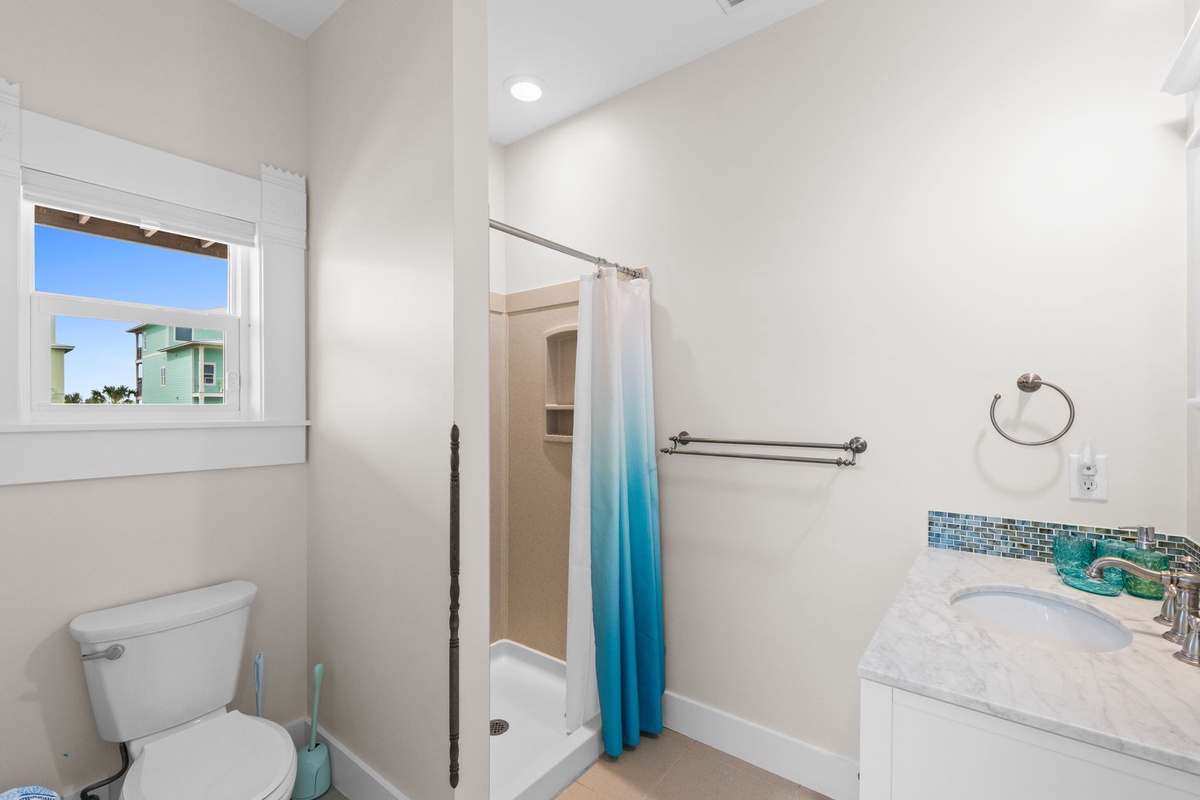 Refresh in your bright, coastal-themed bathroom with sparkling tile accents and modern fixtures for a perfect seaside getaway experience.