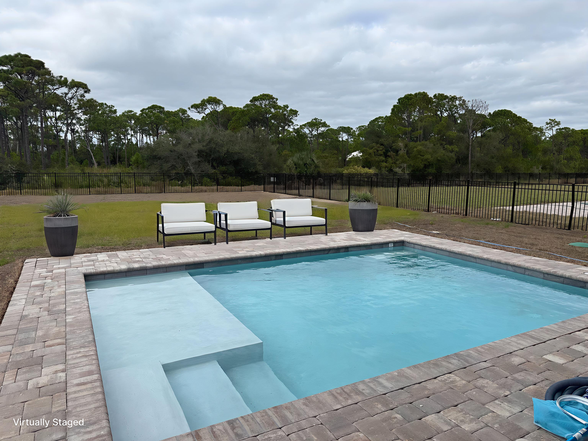 Dive into your private oasis with crystal-clear waters and comfortable poolside seating overlooking lush natural surroundings.