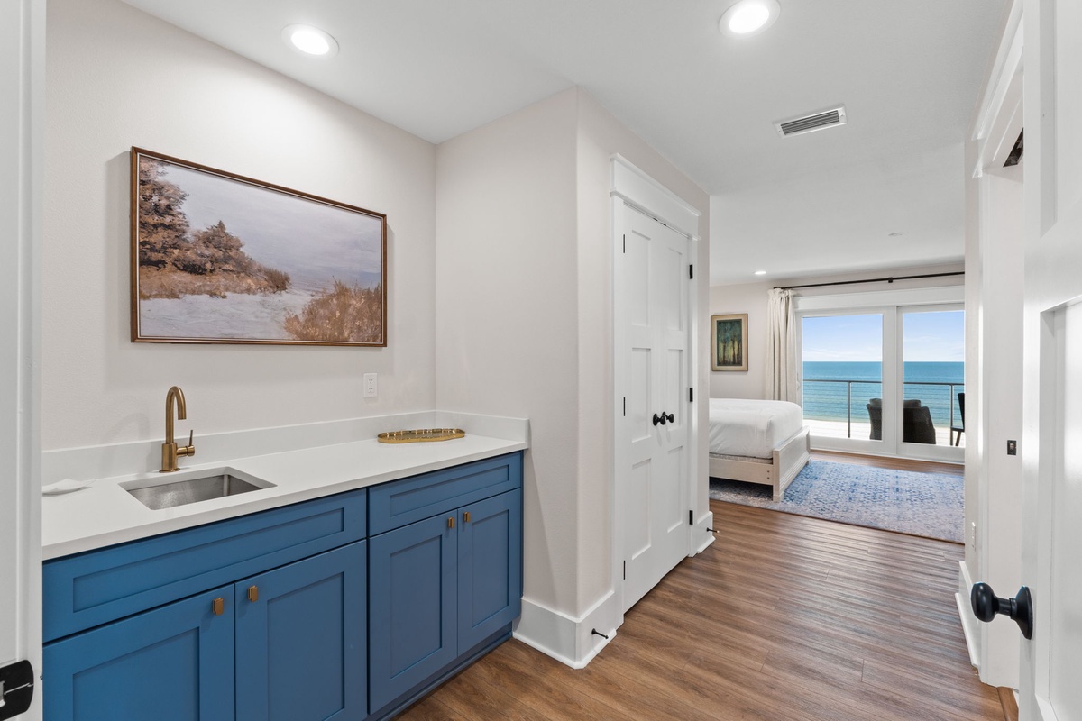You'll love the convenience of this stylish wet bar just steps from your bedroom, perfect for morning coffee or evening cocktails. The ocean views beyond invite endless relaxation.
