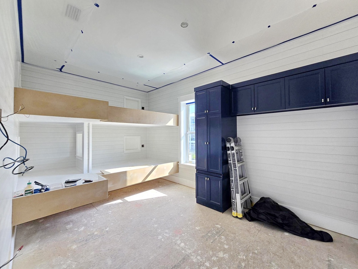 This room is currently under renovation, being thoughtfully prepared to provide comfortable sleeping space for your group with its custom-built bunk beds and ample navy cabinetry for storage.