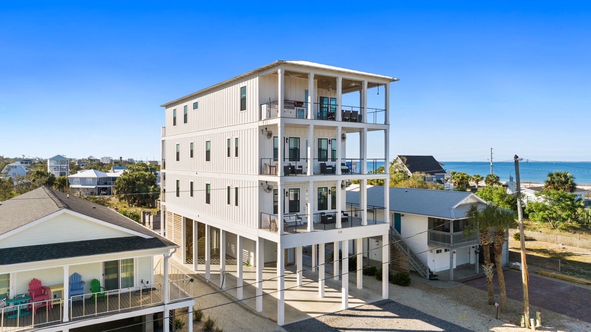 Modern beachfront property with multiple balconies offering stunning ocean views in a quiet coastal neighborhood.