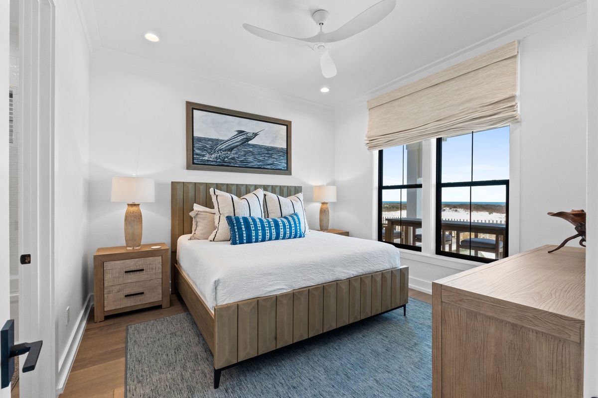 Wake up to beautiful views in your coastal retreat, featuring a comfortable bed and ocean-inspired decor.