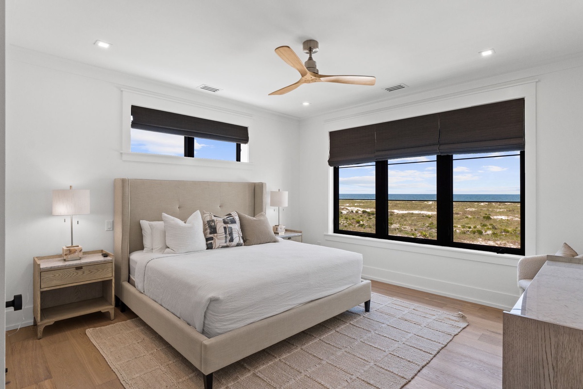 Your peaceful retreat with coastal views. Drift off in the plush bed while gentle breezes from the ceiling fan and natural light create your perfect sanctuary.