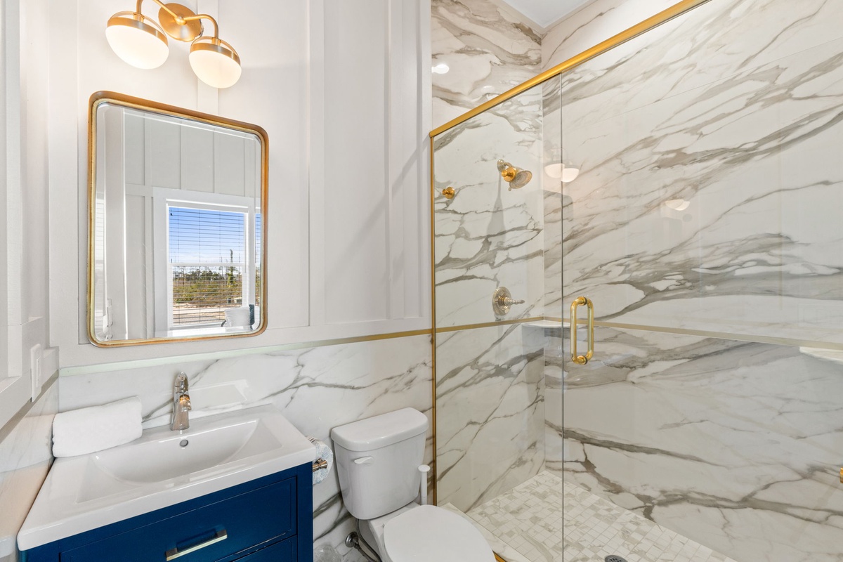 Luxurious marble bathroom with elegant gold fixtures and spacious glass shower—your private spa retreat.