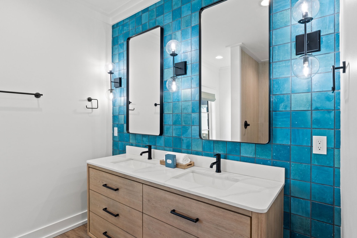 Refresh in your stunning double vanity bathroom featuring vibrant turquoise tiles, modern fixtures, and warm wood accents.