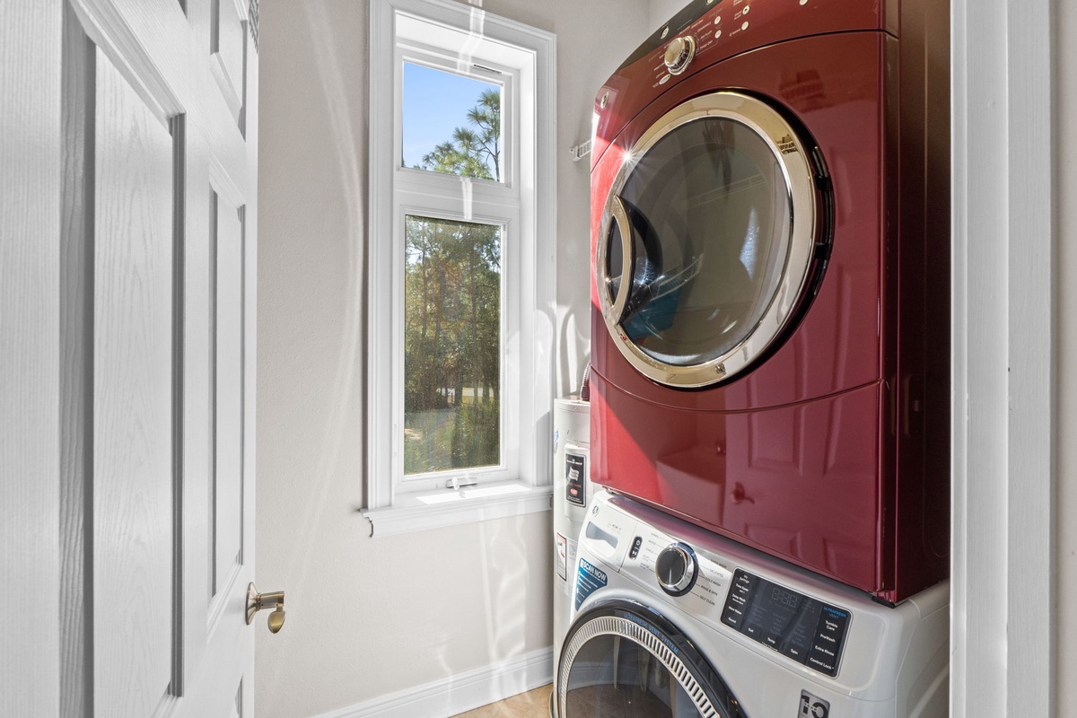 Your private laundry room features stacked washer and dryer units with natural light from the window, making it easy to keep your clothes fresh.