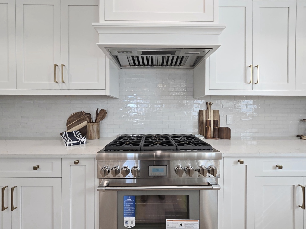 Step into your chef's paradise with this gleaming kitchen featuring professional-grade appliances and pristine white cabinetry perfect for creating memorable meals.