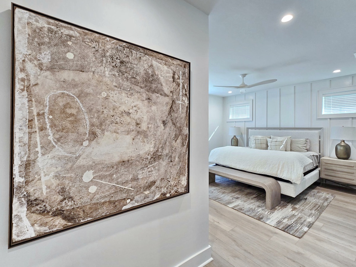 Your serene bedroom features modern artwork, elegant furnishings, and plenty of natural light for a peaceful retreat.