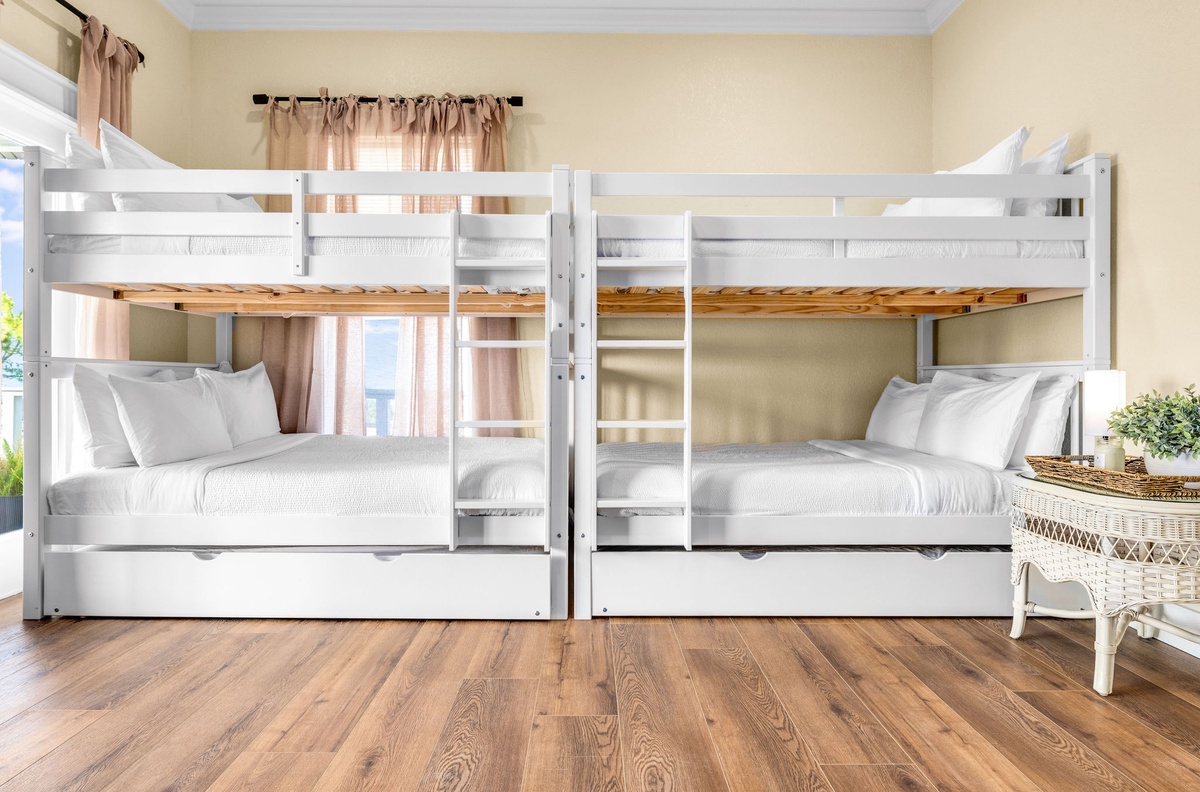 Rest comfortably in your cozy bunk room featuring crisp white linens and warm natural light filtering through soft curtains.