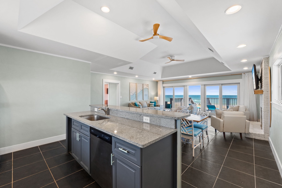 Gather around the spacious island where your family meals begin, with sweeping ocean views framing every moment. Light pours through expansive windows as ceiling fans keep you comfortable, and open-concept living invites easy beachside relaxation.