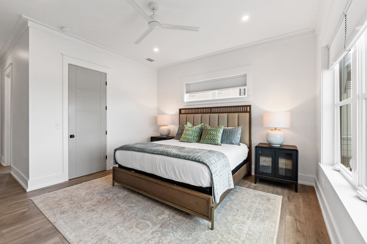 Sink into crisp white linens and soft pillows in your serene bedroom, where warm lighting and thoughtful touches create the perfect retreat.