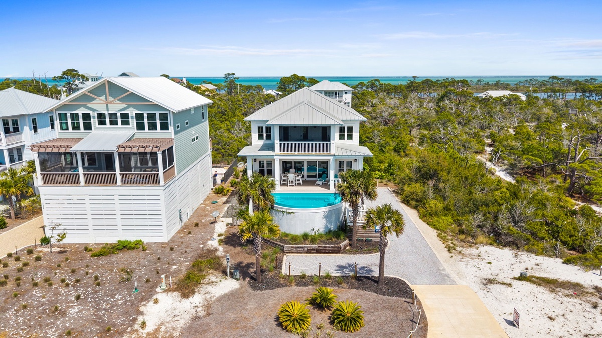 Stunning coastal property with private pool nestled among natural vegetation, just steps from turquoise waters.