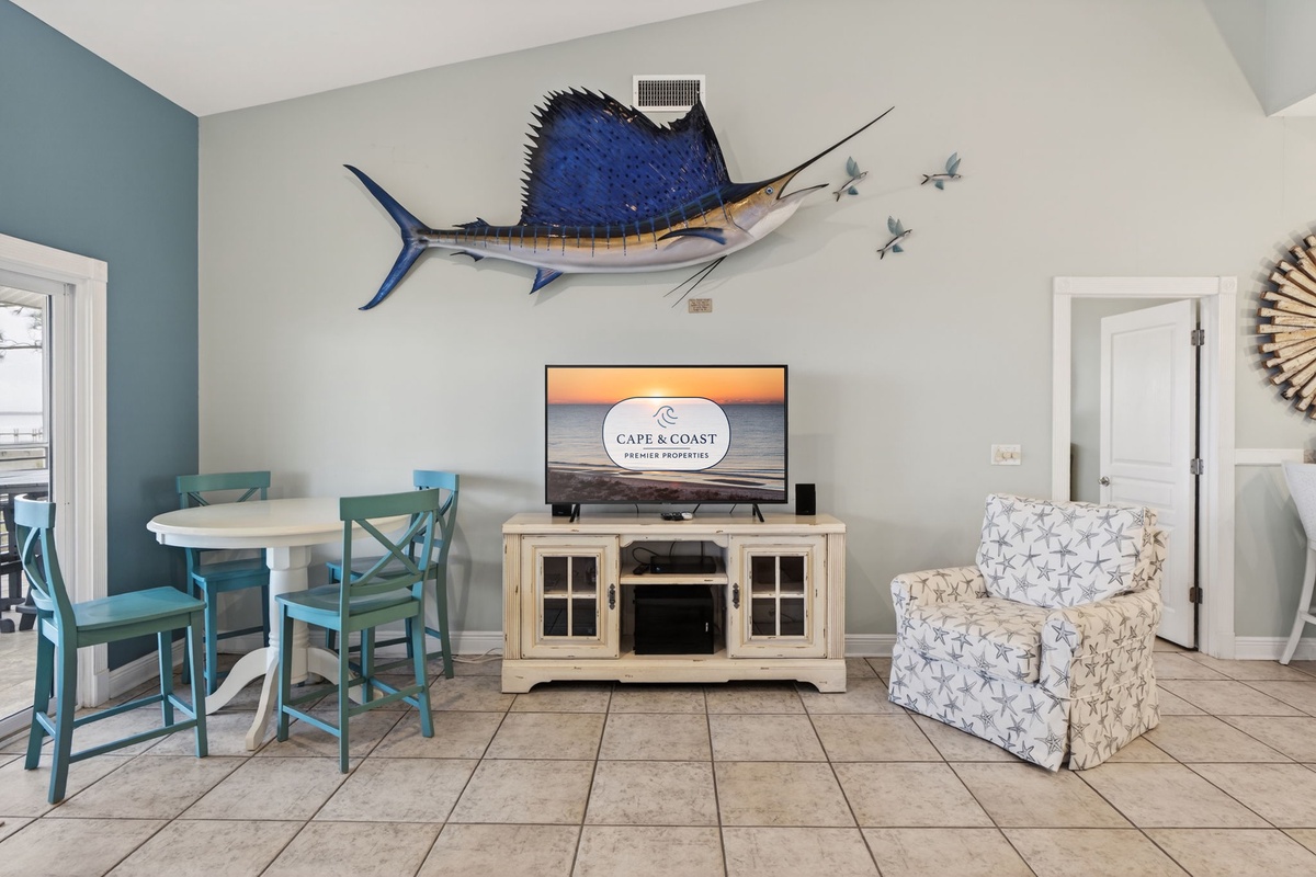 Relax in your coastal-themed living area where nautical charm meets modern comfort, complete with dining space and entertainment center for your perfect beach getaway.