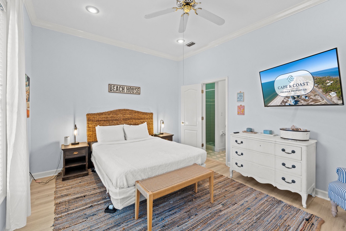 Unwind in your coastal bedroom featuring crisp white linens, charming wicker headboard, and beachy décor that creates the perfect seaside retreat atmosphere.