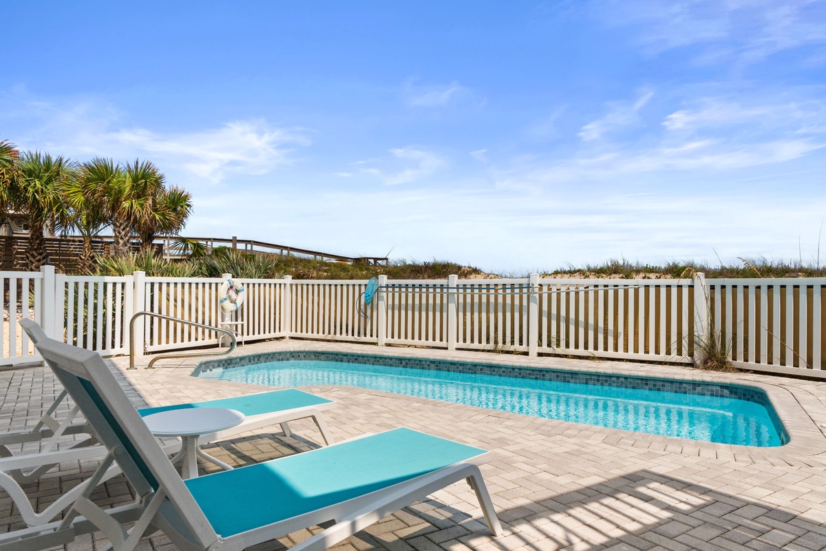 Your private pool awaits, framed by swaying palms and coastal breezes just beyond the fence—perfect for sun-soaked afternoons and refreshing dips.